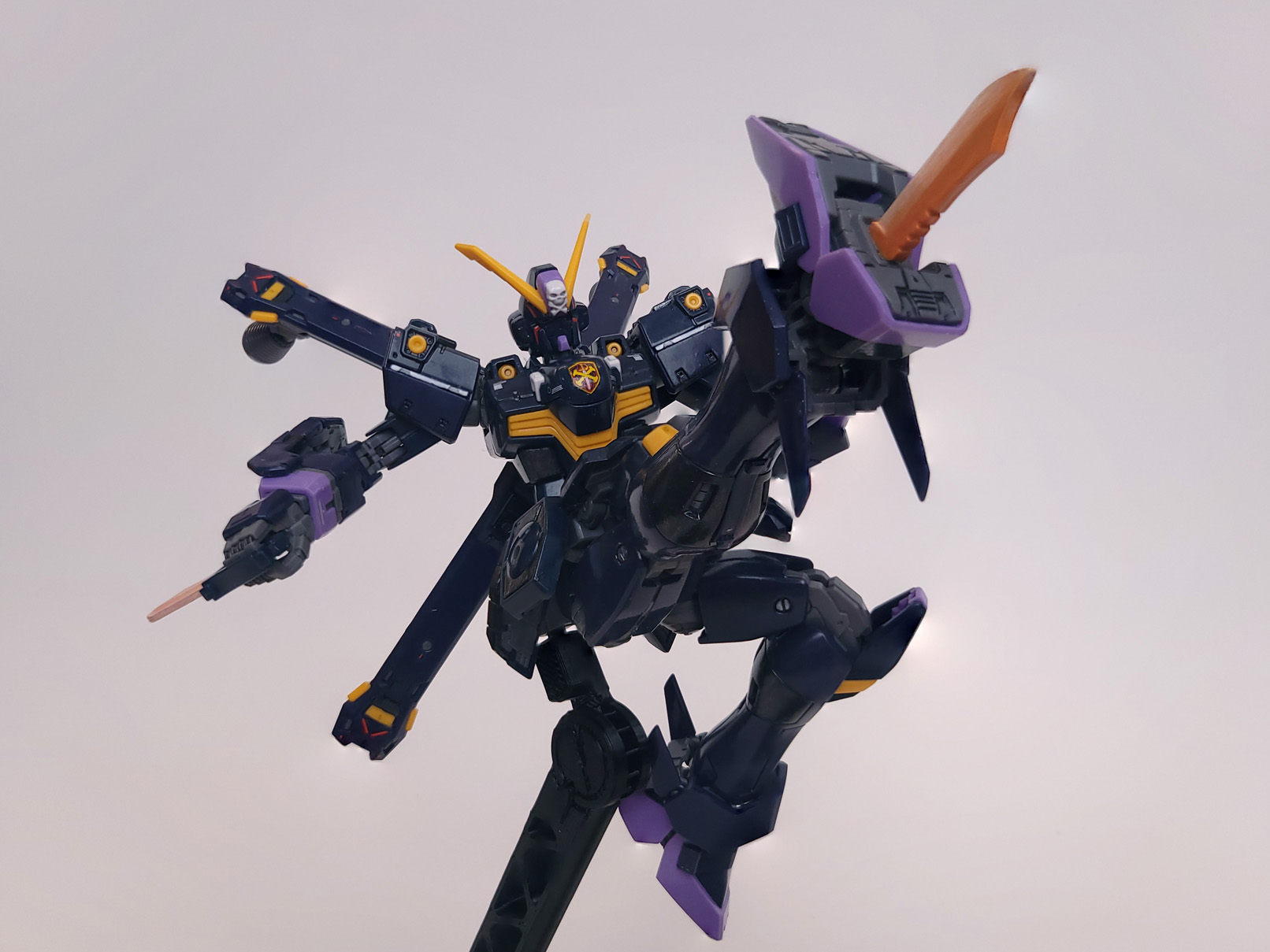 Uncloaked, the gundam is performing a high kick; a red-hot knife blade has emerged from the foot