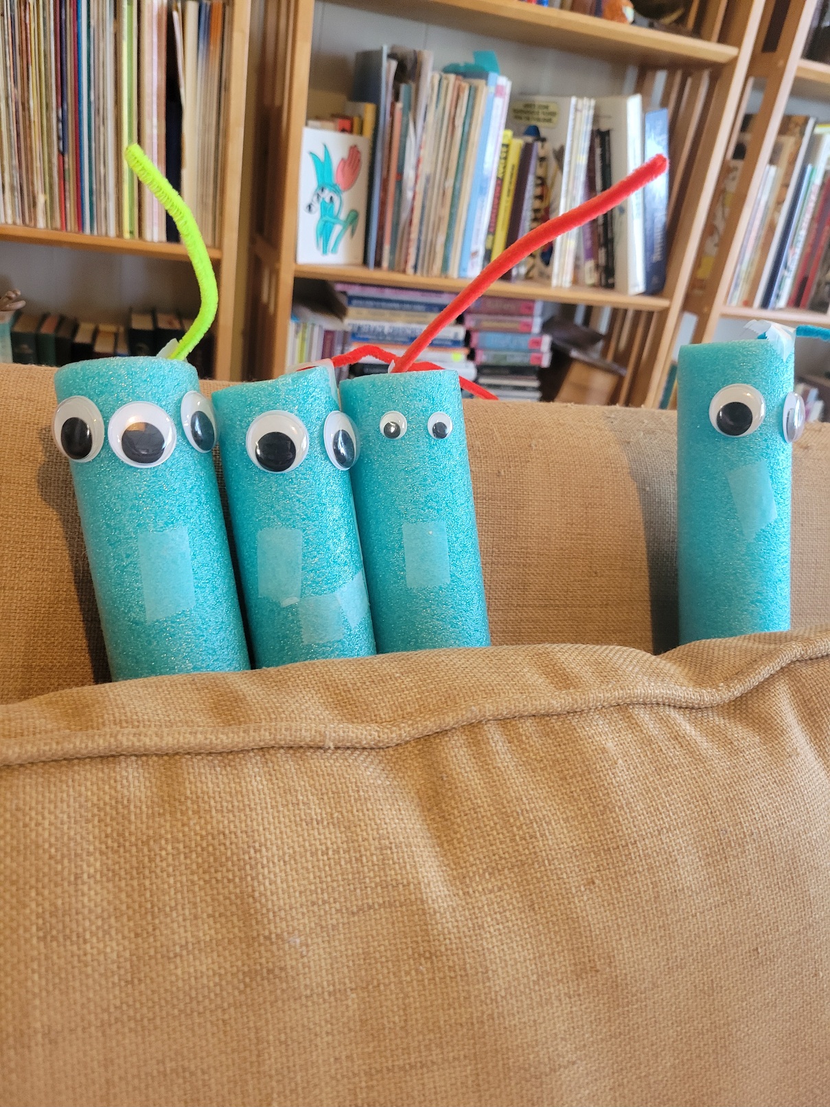a close up of four of the worms. One has three eyes. All have a small piece of scotch tape for a mouth except for one that has three in roughly a smile shape