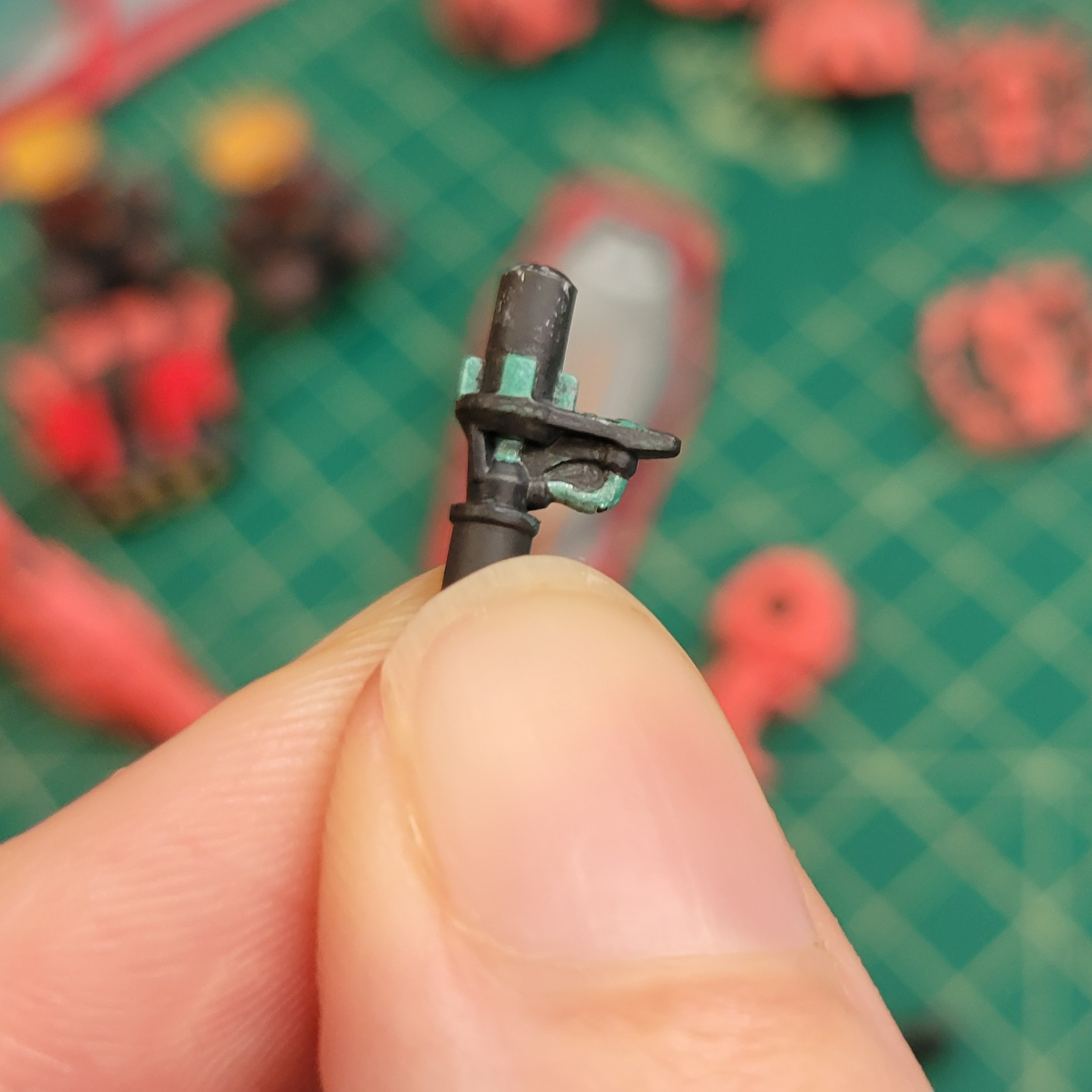 a close up of the profile of a bit-mount on the HG GQX Red Gundam. There is a shiny green tube and post surrounded by a grey mechanical shape