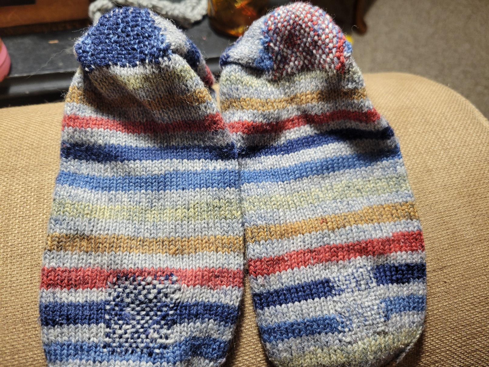two knit socks, sole side up. There is a woven section on each heel and ball contrasting with the otherwise knit fabric