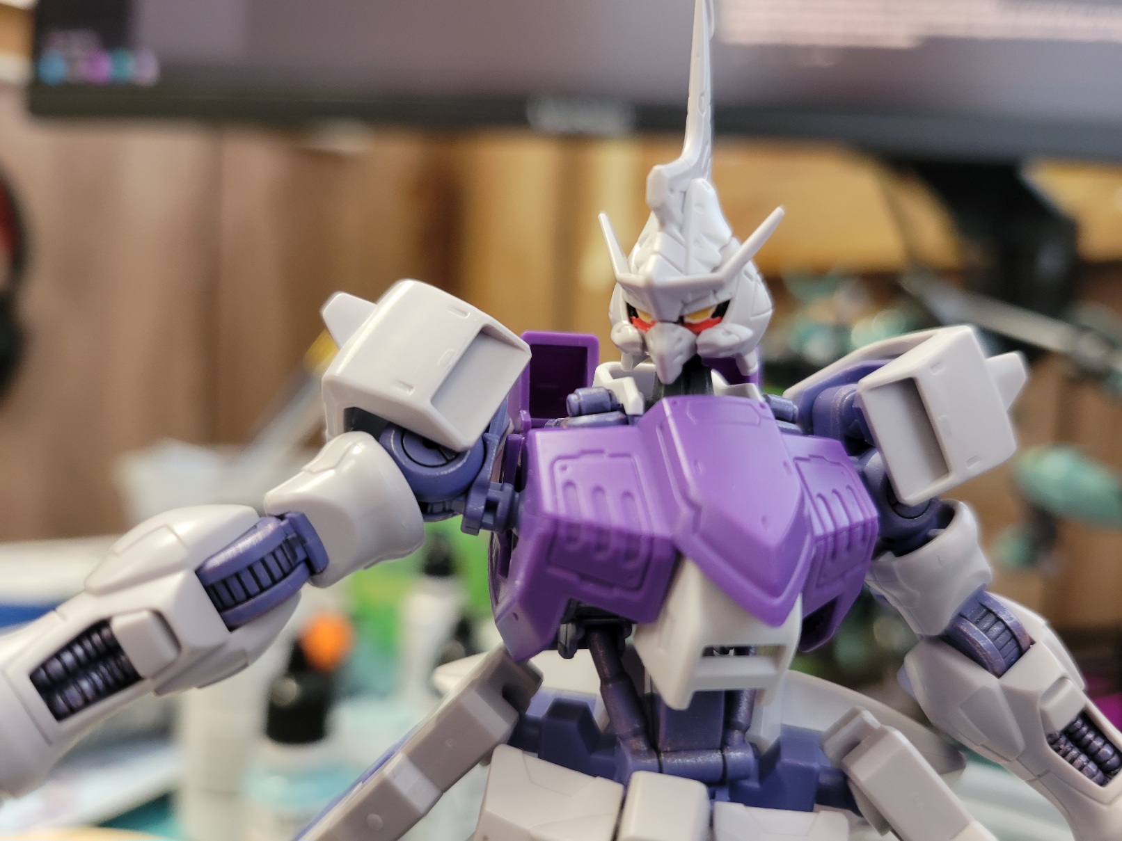 HG Kimaris's bust: purple chest, light grey and white head with yellow eyes surrounded by shadows save a stripe of brilliant red underneath