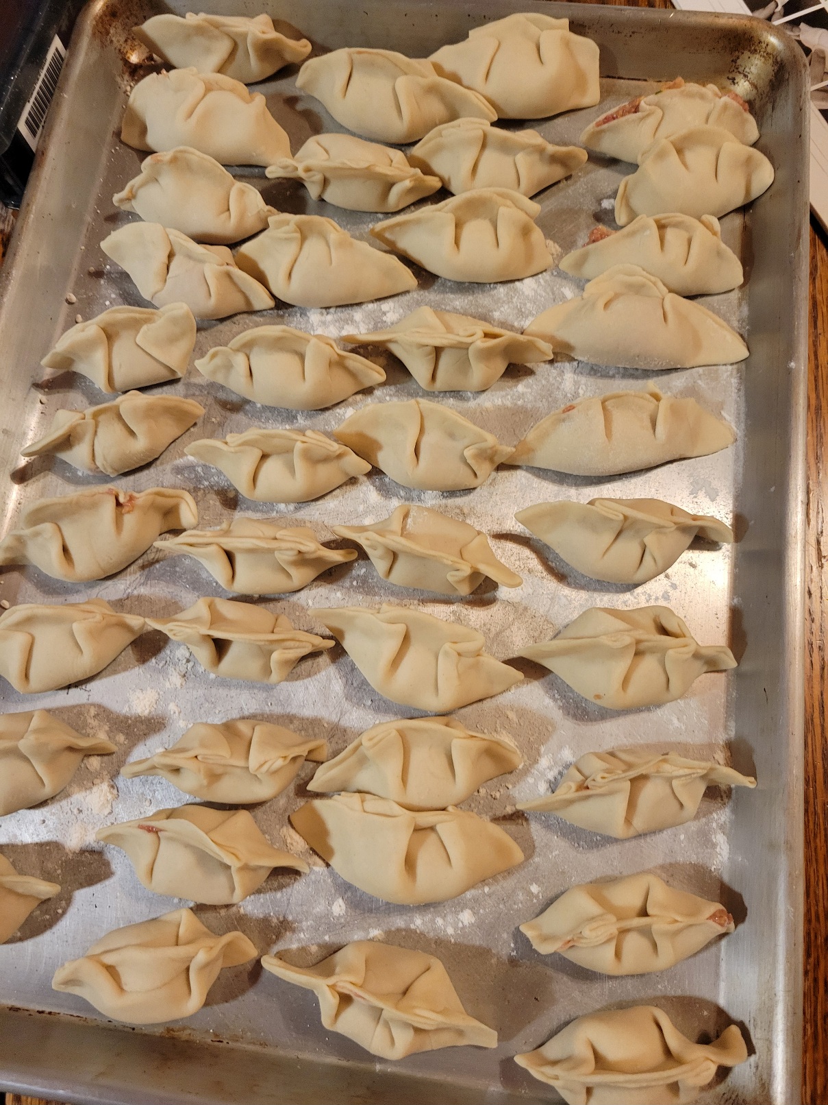 A sheet tray full of hand-crimped gyoza