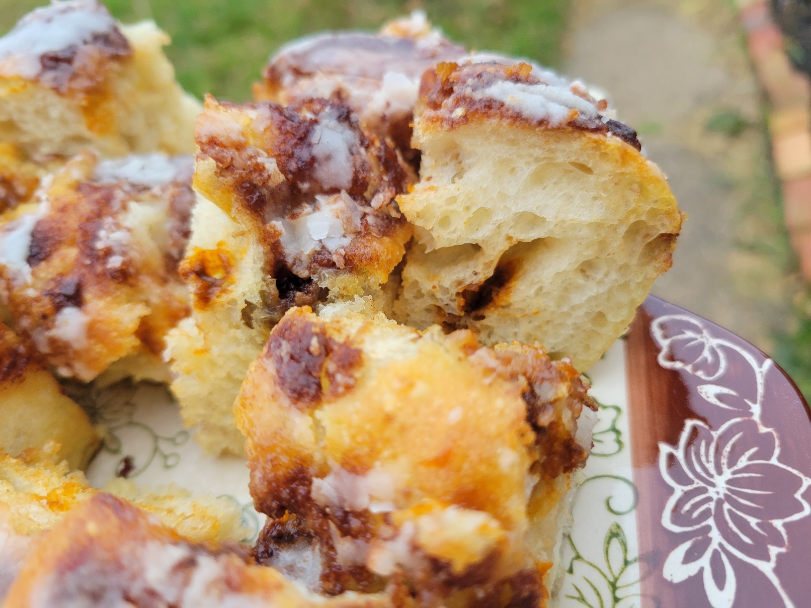 A platter of squares of cinnamon roll focaccia, crowned with icing