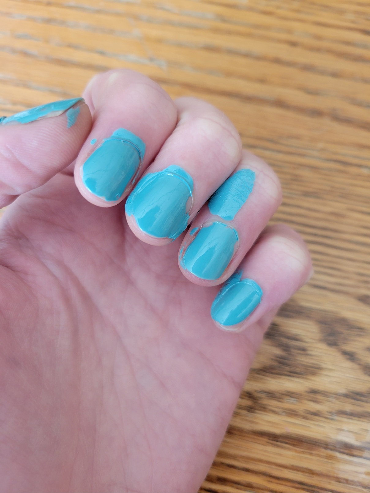 my partially closed fist to show off nail polish. The blue-green color has been liberally applied to both skin and nail