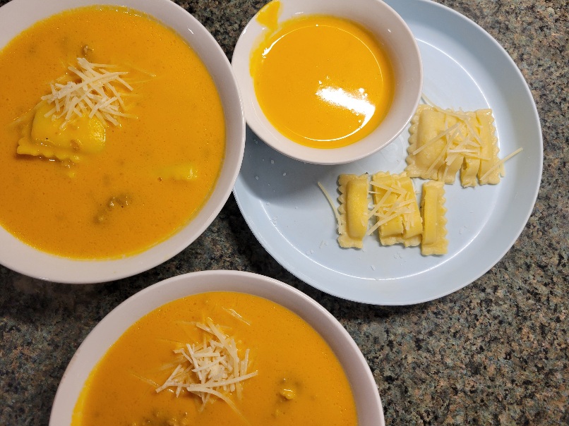 three bowls of squash soup with ravioli and sausage. The smallest bowl is 'deconstructed', with the ravioli on the side cut into pieces